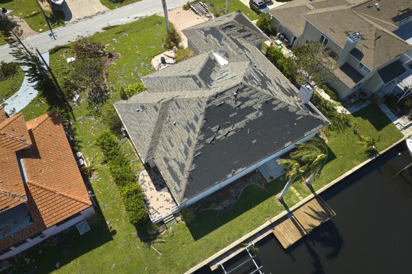 Hurricane Ian destroyed house roof in Florida residential area. Natural disaster and its consequences.